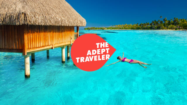 Lady swimming by Tiki Hut in Bora Bora, French Polynesia