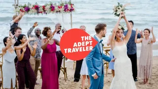 Newlywed bride throwing flowers on a beach during their destination wedding
