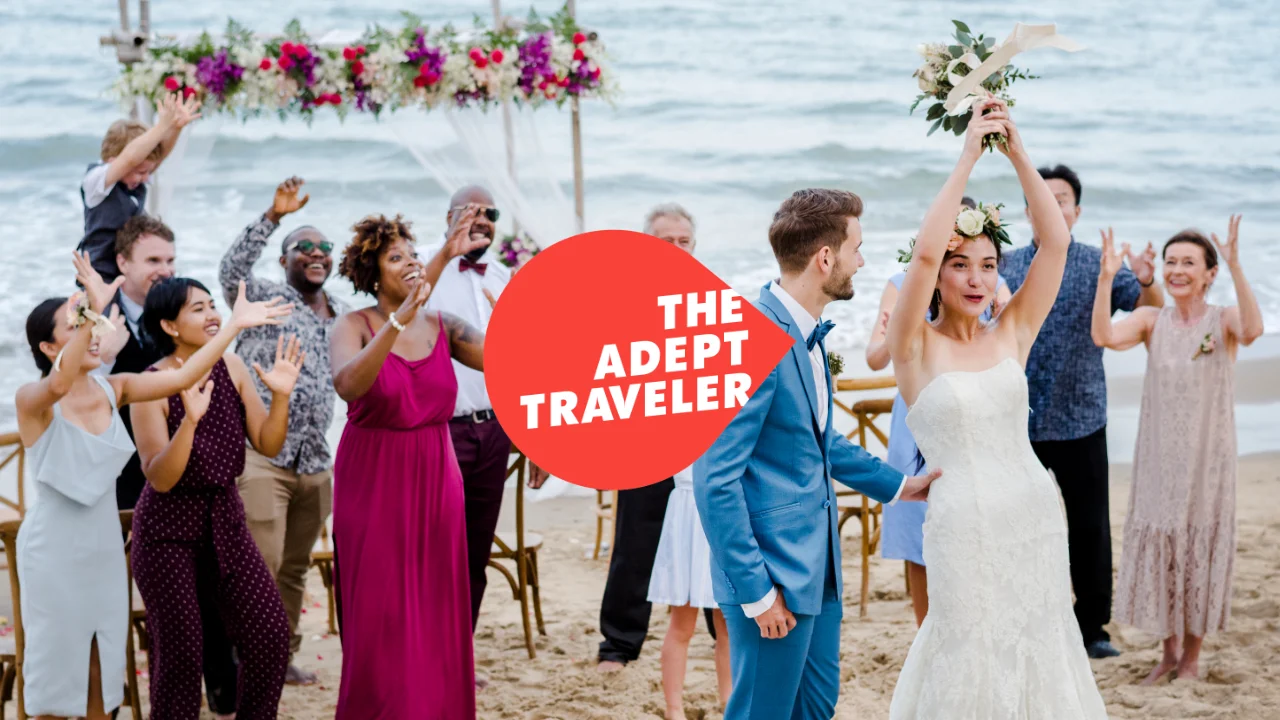 Newlywed bride throwing flowers on a beach during their destination wedding