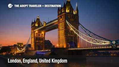 ower Bridge glowing at dusk, its lights reflecting on the Thames, viewed from a dramatic low angle.
