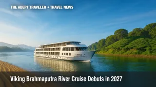 Viking Brahmaputra River Cruise ship gliding past green Assam riverbanks under a clear sky.