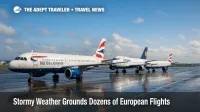 Grounded British Airways and Lufthansa jets glisten on a rain-wet Heathrow ramp after storm-driven European flight cancellations.