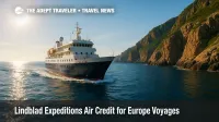A Lindblad Expeditions small ship explores a rocky European coast, showcasing an expedition cruise experience tied to an air credit offer.
