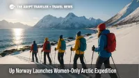 A small group snowshoes along Senja's snowy coast under clear skies during a women-only Arctic expedition.