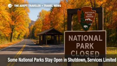 Autumn trees frame a national park entrance road and closed fee station, illustrating national parks shutdown access and suspended fee collection.