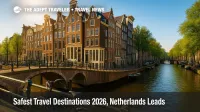 A bright Amsterdam canal scene with historic gabled houses and a bridge, illustrating safest travel destinations 2026 and Netherlands ranking first.