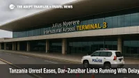 Departures board at Dar es Salaam's Julius Nyerere International Airport with advisory to confirm flights and ferries amid easing unrest