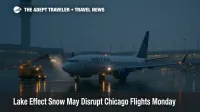 Snow and deicing at O'Hare during a lake effect band, wet tarmac and tower visible, signaling likely flight delays for Chicago travelers