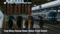 Travelers study the Hualien Station departures board as Fung Wong cleanup leaves east coast Taiwan rail schedules delayed and uneven for several days
