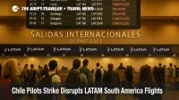 Travelers watch a departure board at Santiago airport showing delays and cancellations after the LATAM pilots strike disrupted South America flights.