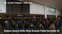 Passengers queue under a departures board at Brussels Airport as the Belgium strike Brussels flights disruption leaves many November 26 flights cancelled