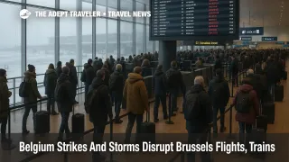 Travelers queue under a departures board at Brussels Airport as Belgium strikes Brussels flights during winter storms, with several services shown cancelled