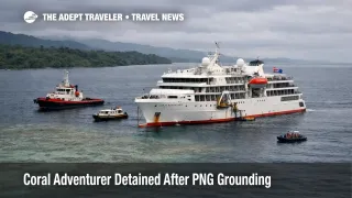Coral Adventurer detention PNG shown by expedition ship anchored off Lae after reef grounding, under overcast skies.