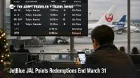JetBlue JAL points redemptions end March 31, 2026, as a traveler checks Tokyo flights on a JFK departures board