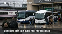 Córdoba to Jaén rail bus swaps, travelers queue for substitute coaches outside Córdoba station under overcast skies.