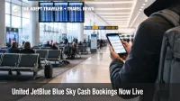 United JetBlue Blue Sky cash bookings shown as a traveler checks flight options on a phone in a JFK concourse