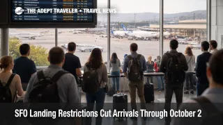 Passengers wait near an arrivals board at SFO as landing restrictions raise San Francisco airport delay risk